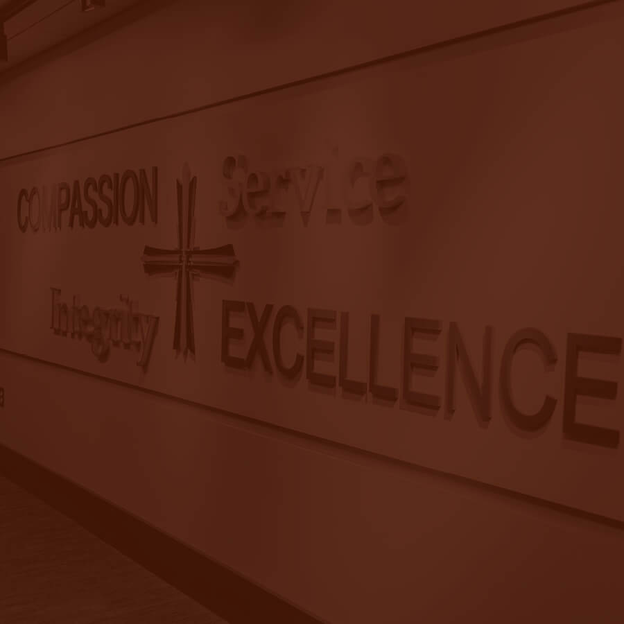 Interior hallway signage surrounding the Ann Arbor logo listing: compassion, service, integrity, and excellence.