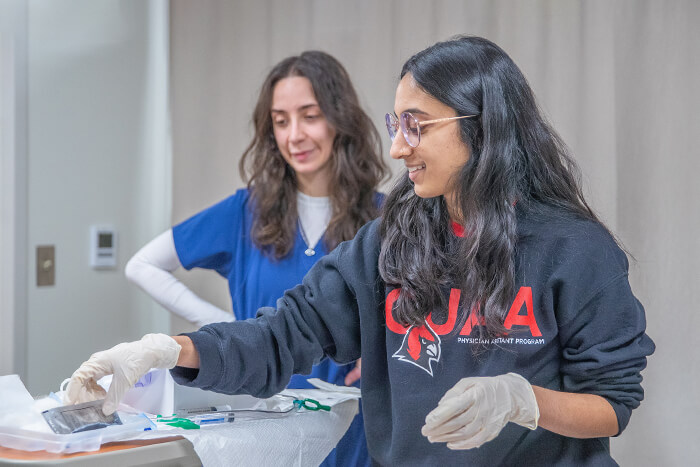 A student prepares to care for her patient during a simulation exercise.